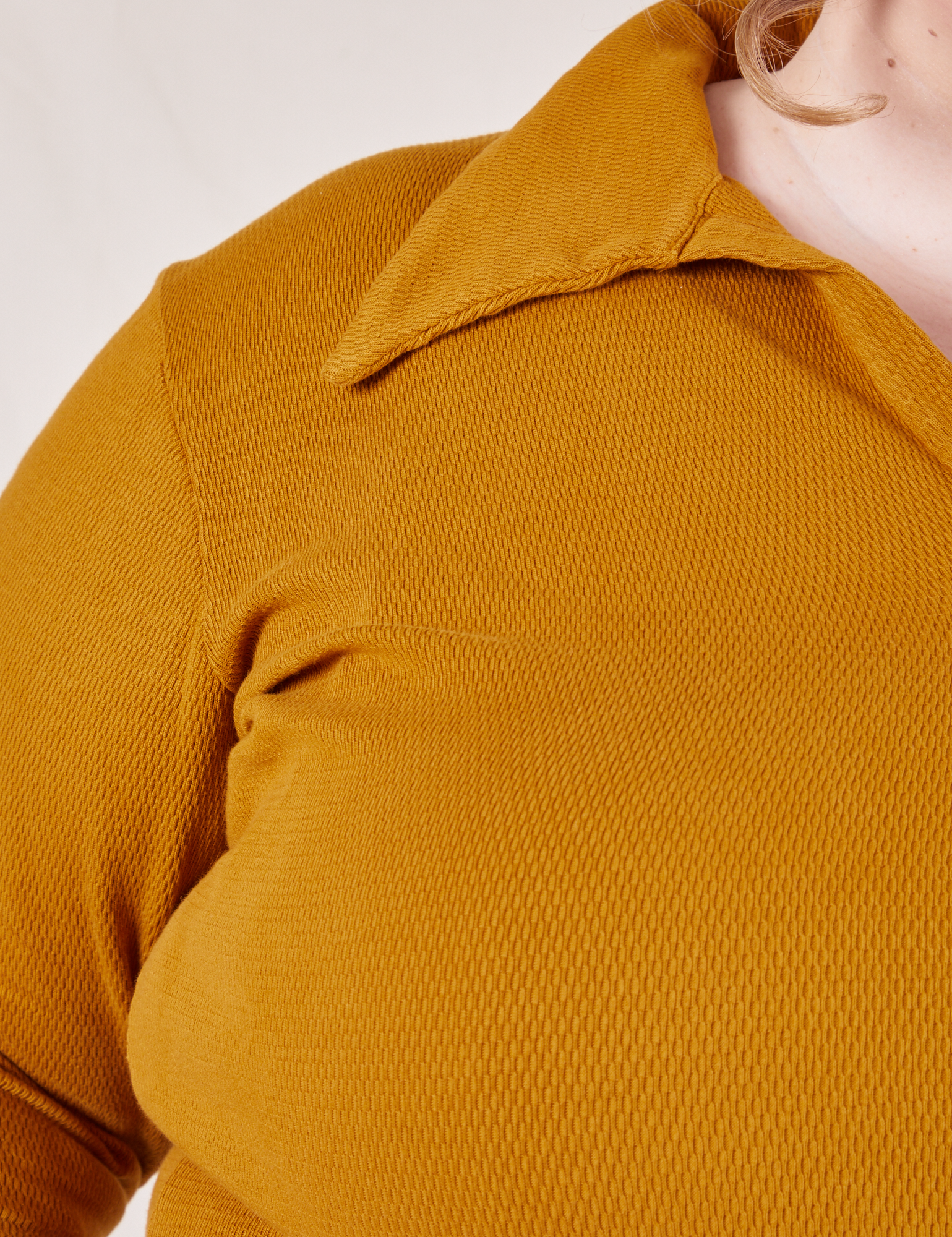 Front close up of Long Sleeve Fisherman Polo in Spicy Mustard worn by Catie