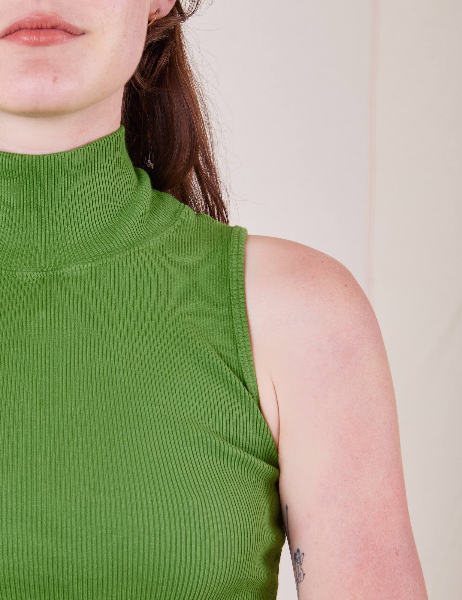 Front close up of Sleeveless Essential Turtleneck in Bright Olive worn by Alex