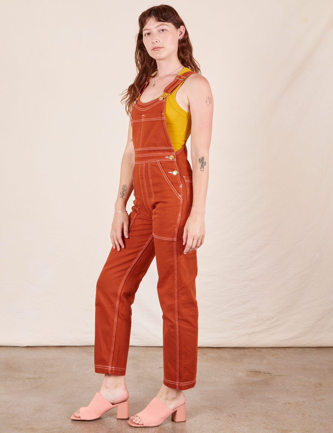 Angled view of Original Overalls in Burnt Terracotta worn by Alex