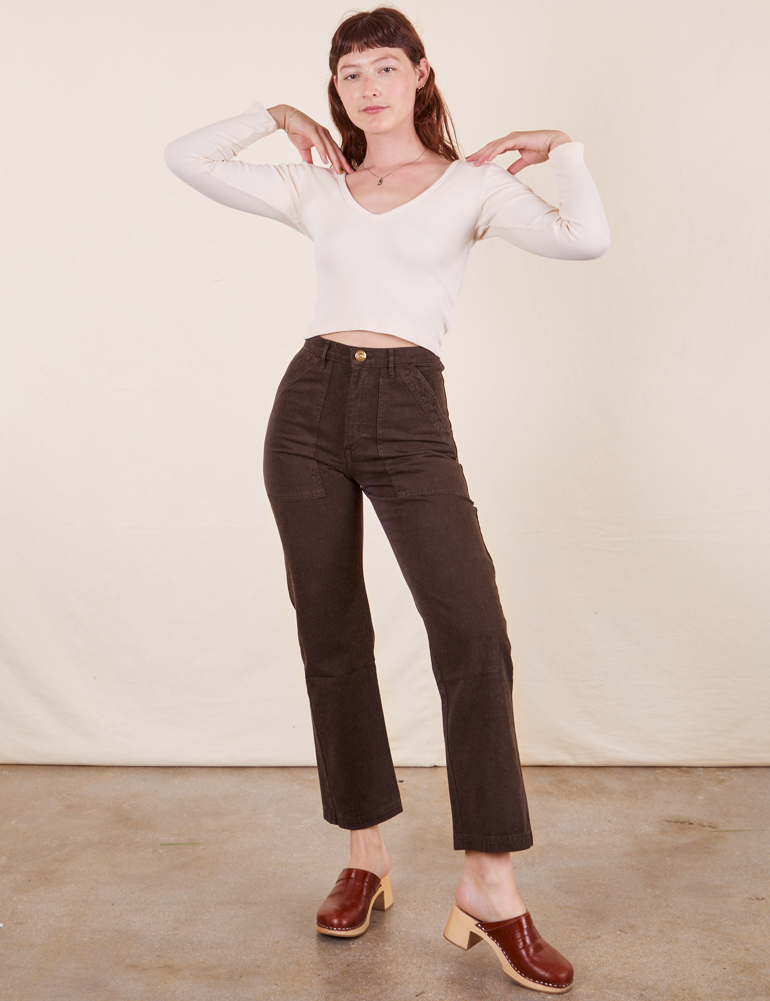 Alex is 5&#39;8&quot; and wearing XS Work Pants in Espresso Brown paired with vintage off-white Long Sleeve V-Neck Tee