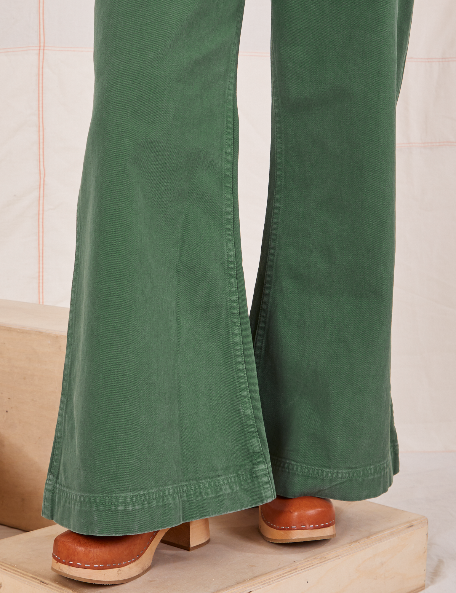 Pant leg close up of Bell Bottoms in Dark Emerald Green worn by Hana