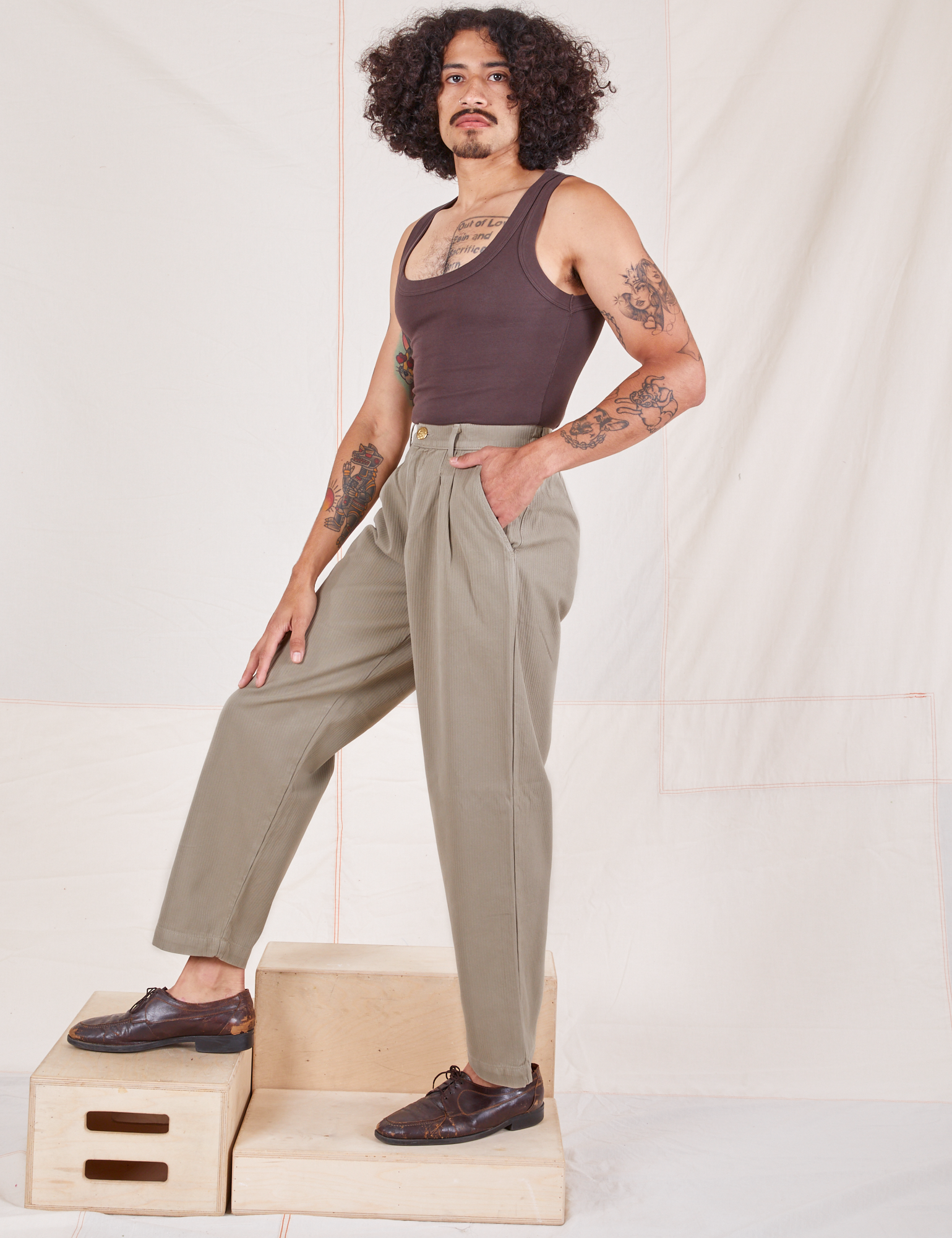 Side view of Heritage Trousers in Khaki Grey and espresso brown Tank Top worn by Jesse