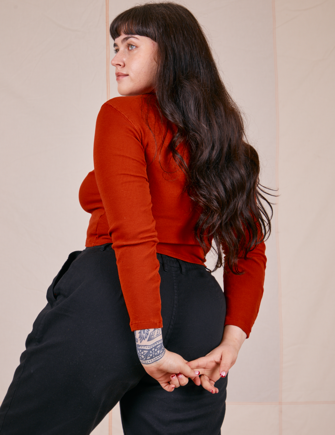 Angled back view of Essential Turtleneck in Paprika worn by Sydney