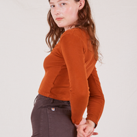 Side view of Long Sleeve V-Neck Tee in Burnt Terracotta worn by Alex
