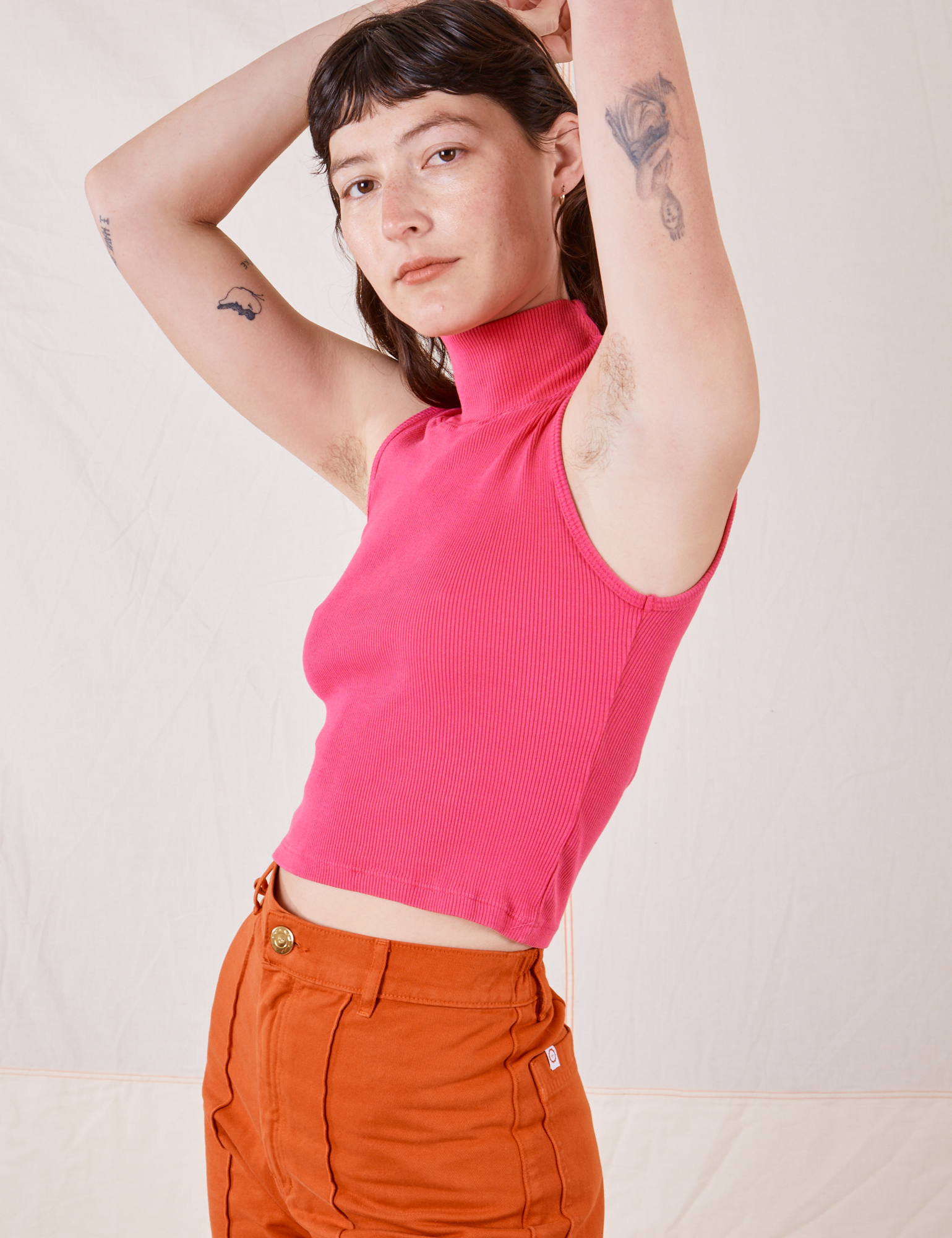 Side view of Sleeveless Essential Turtleneck in Hot Pink worn by Alex