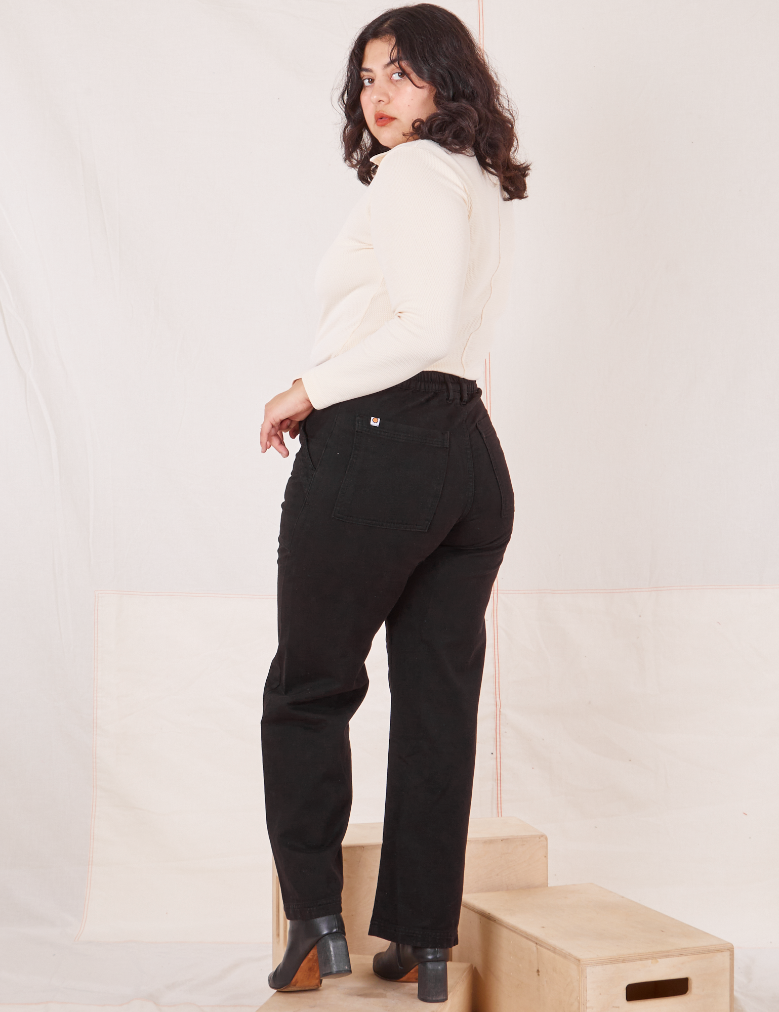 Angled back view of Organic Work Pants in Basic Black worn by Melanie