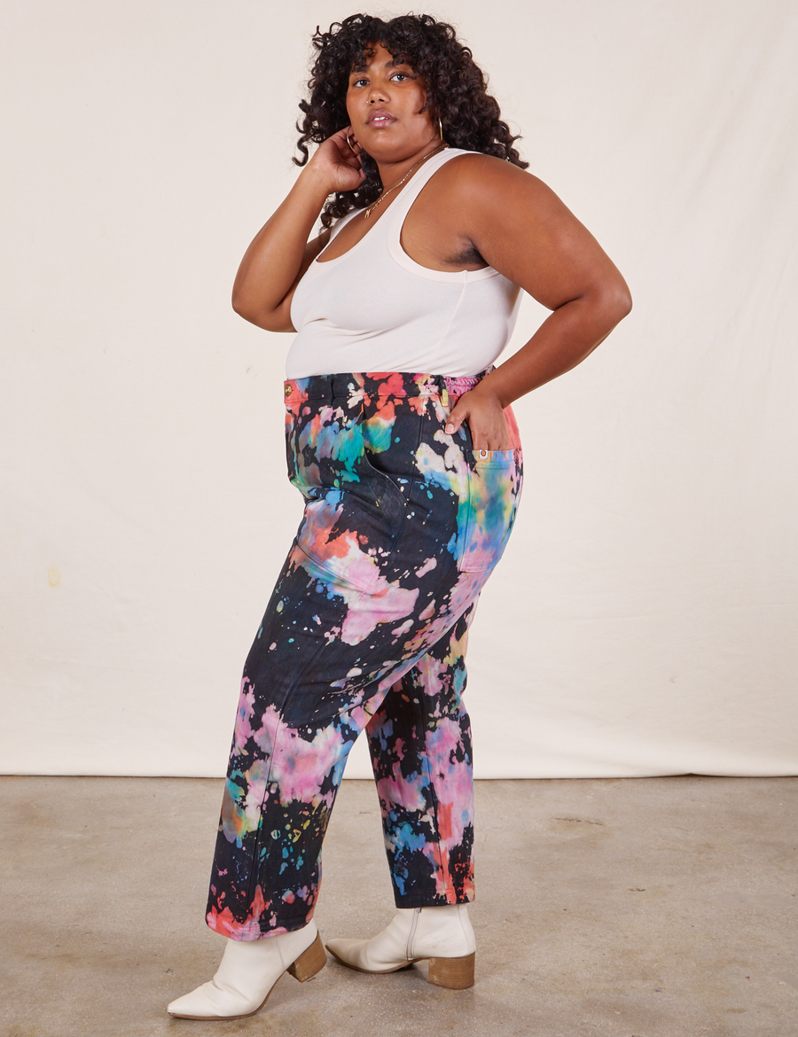 Side view of Rainbow Magic Waters Work Pants and vintage off-white Tank Top worn by Morgan