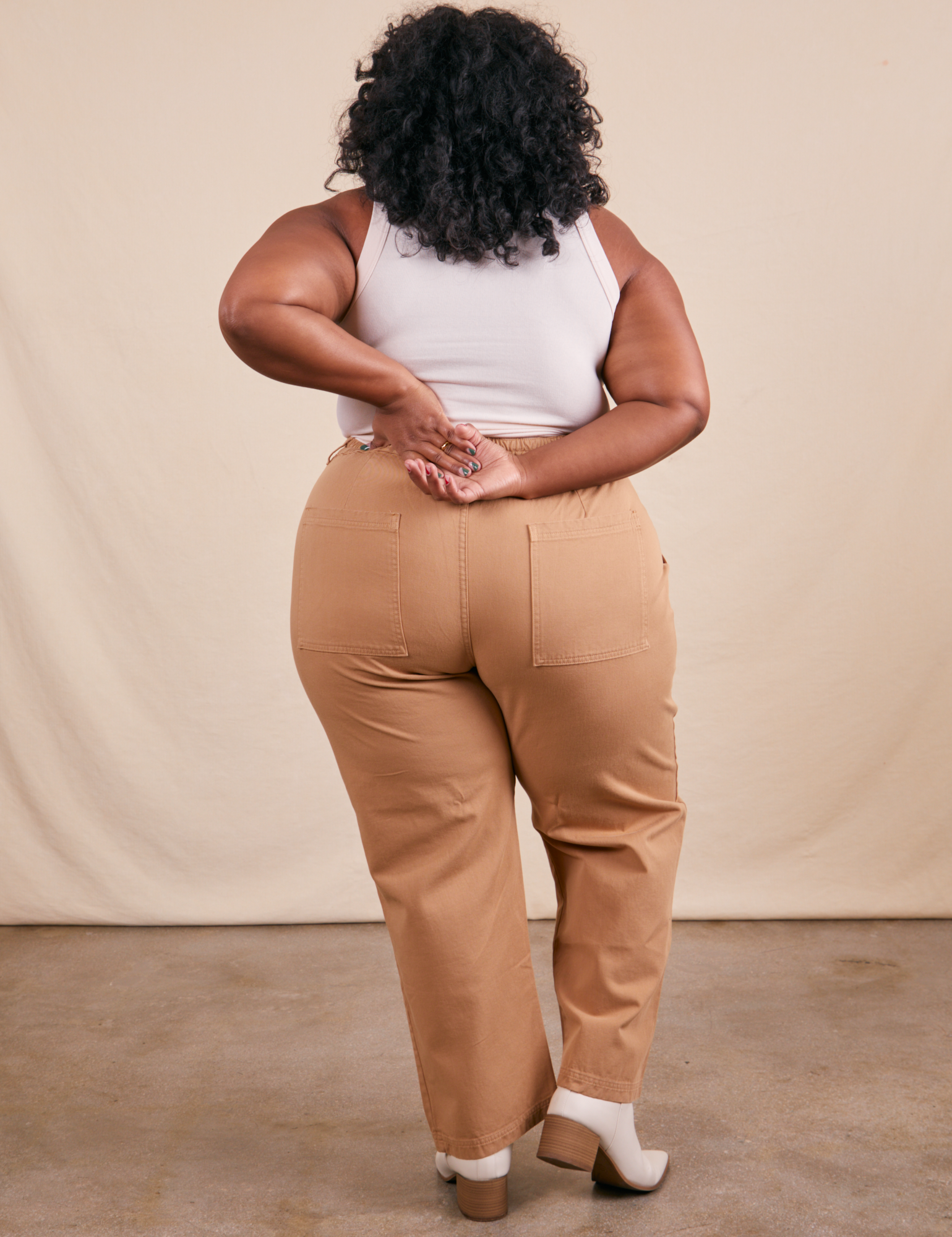 Back view of Work Pants in Tan and vintage off-white Tank Top on Morgan
