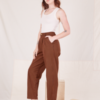 Angled view of Checker Trousers in Brown and vintage off-white Tank Top worn by Alex
