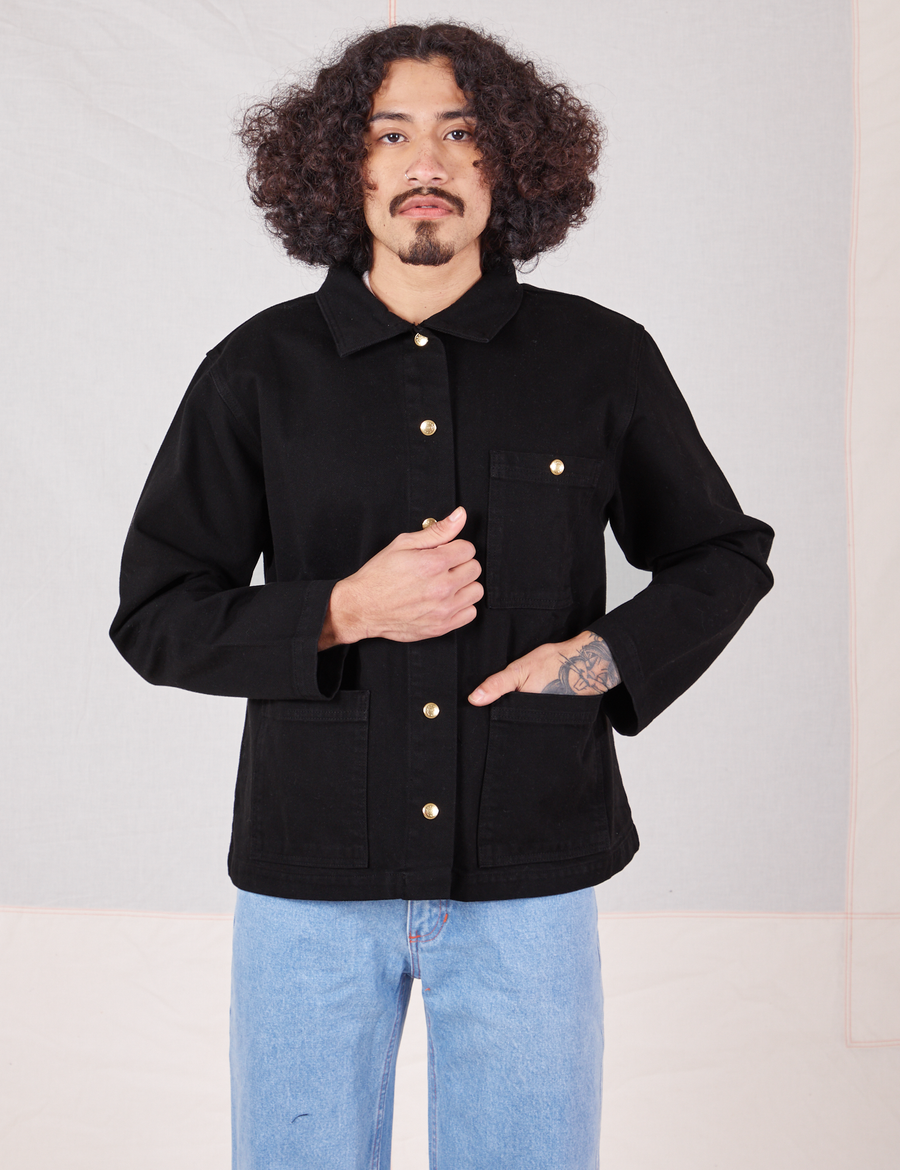 Jesse is wearing a buttoned up Denim Work Jacket in Basic Black paired with light wash Sailor Jeans