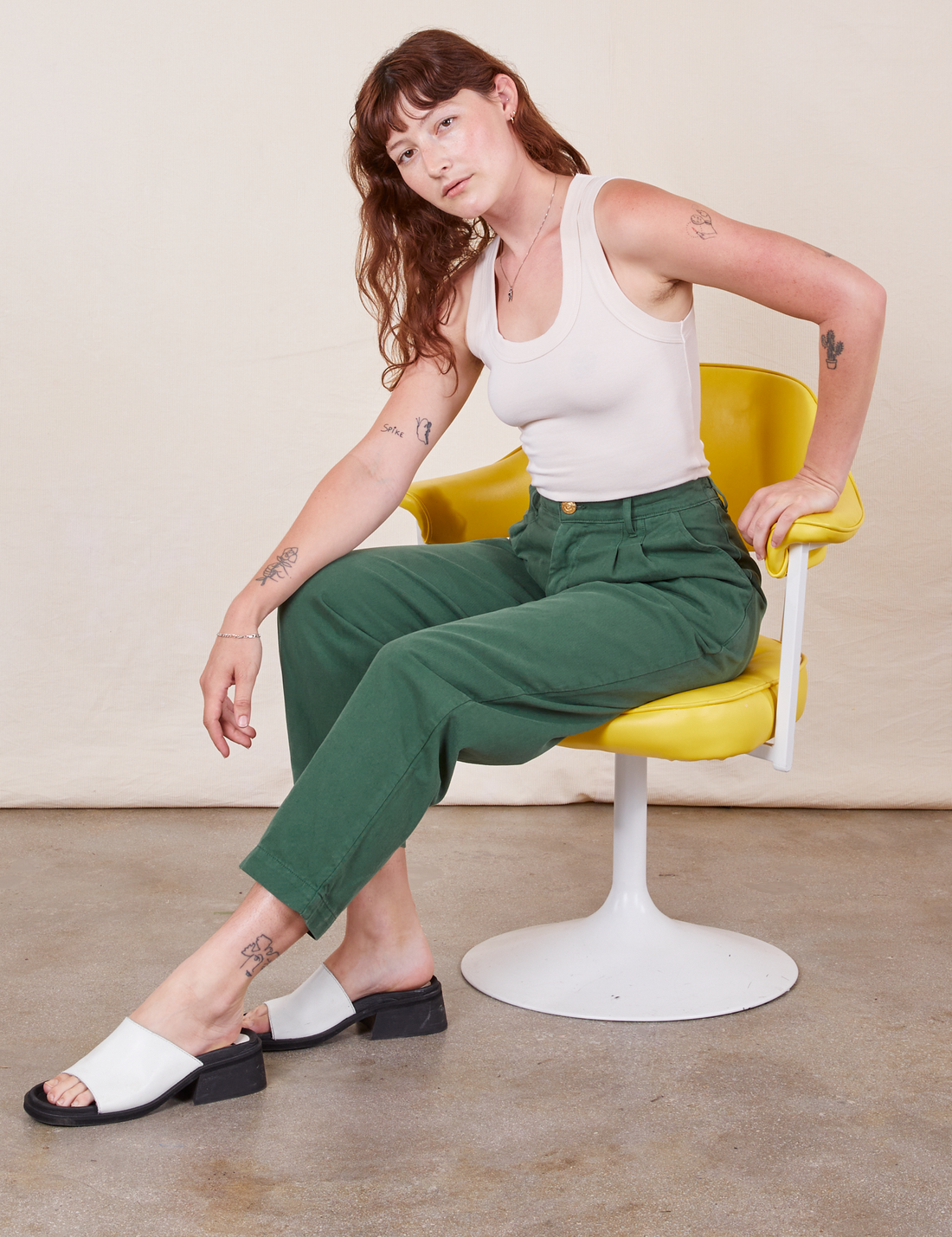 Alex is wearing Heavyweight Trousers in Dark Emerald Green and a vintage off-white Tank Top.
