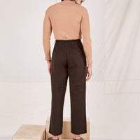 Back view of Heritage Trousers in Espresso Brown and tan Essential Turtleneck worn by Jesse