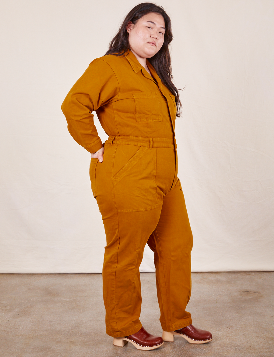 Side view of Everyday Jumpsuit in Spicy Mustard worn by Ashley