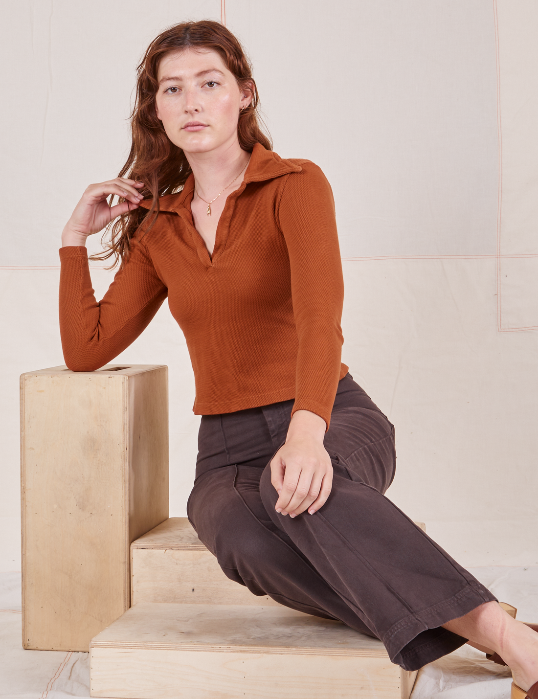 Alex is wearing Long Sleeve Fisherman Polo in Burnt Terracotta and espresso brown Western Pants