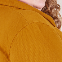 Long Sleeve Fisherman Polo in Spicy Mustard shoulder close up on Catie