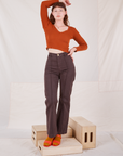 Alex is wearing Long Sleeve V-Neck Tee in Burnt Terracotta and espresso brown Western Pants