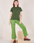 Alex is wearing Organic Vintage Tee in Dark Emerald Green and gross green Western Pants