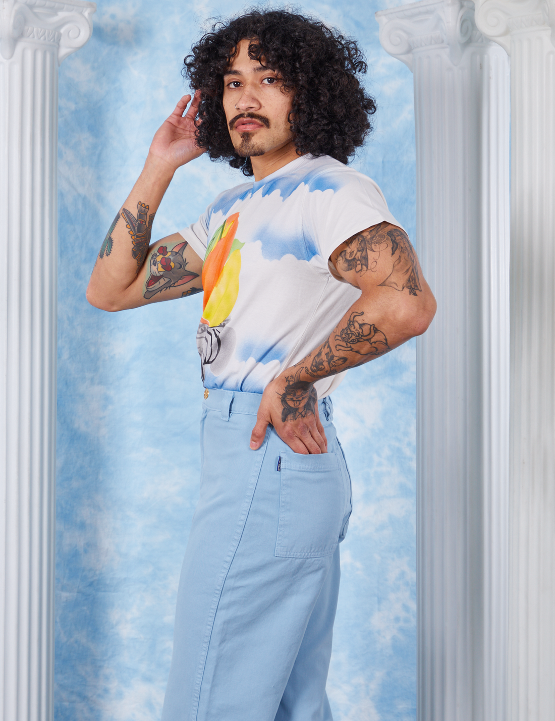 Peach Airbrush Organic Tee side view on Jesse wearing baby blue Bell Bottoms