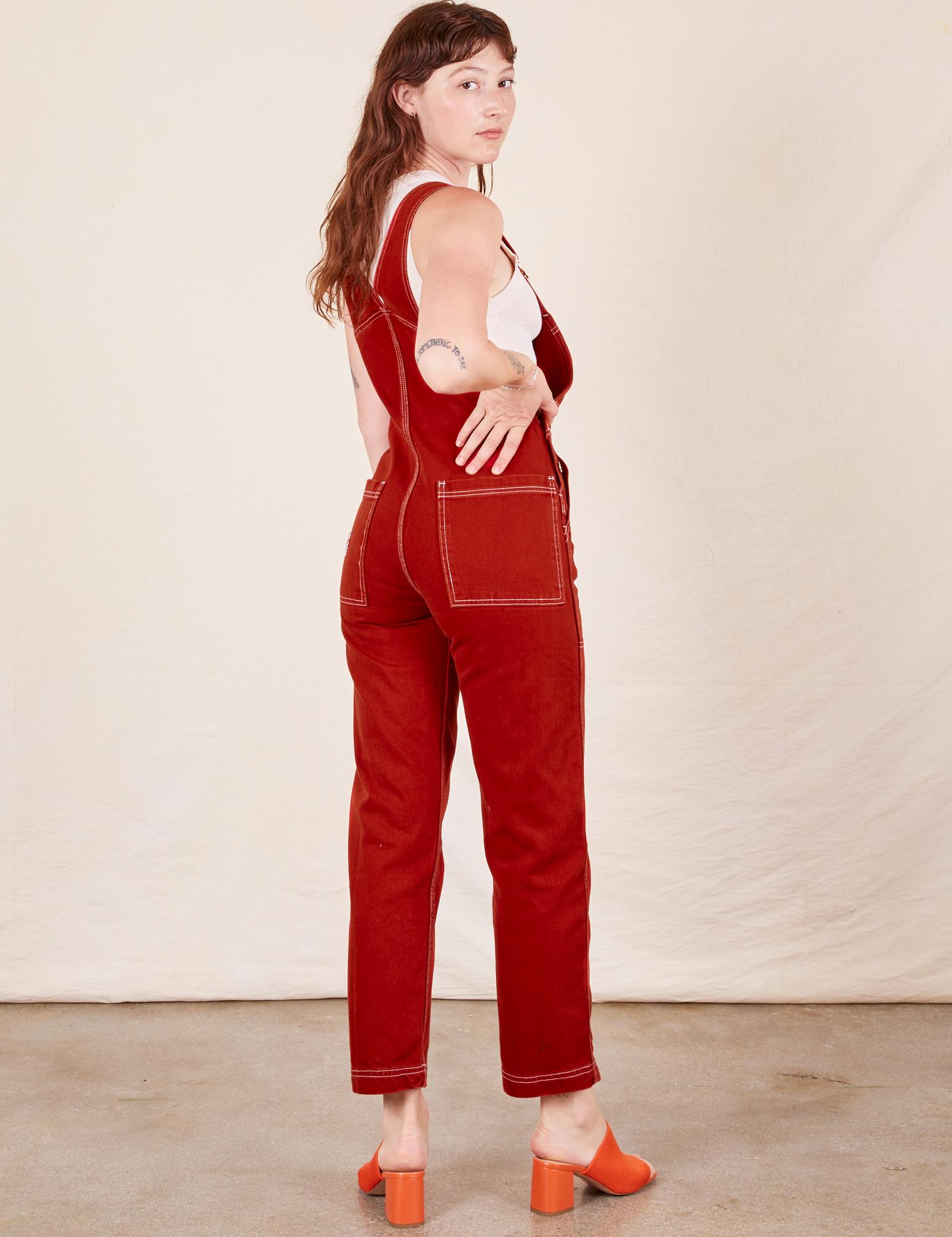 Angled back view of Original Overalls in Paprika worn by Alex
