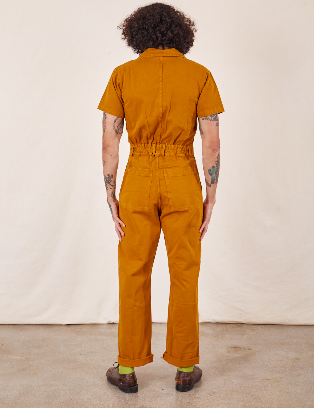 Back view of Short Sleeve Jumpsuit in Spicy Mustard worn by Jesse