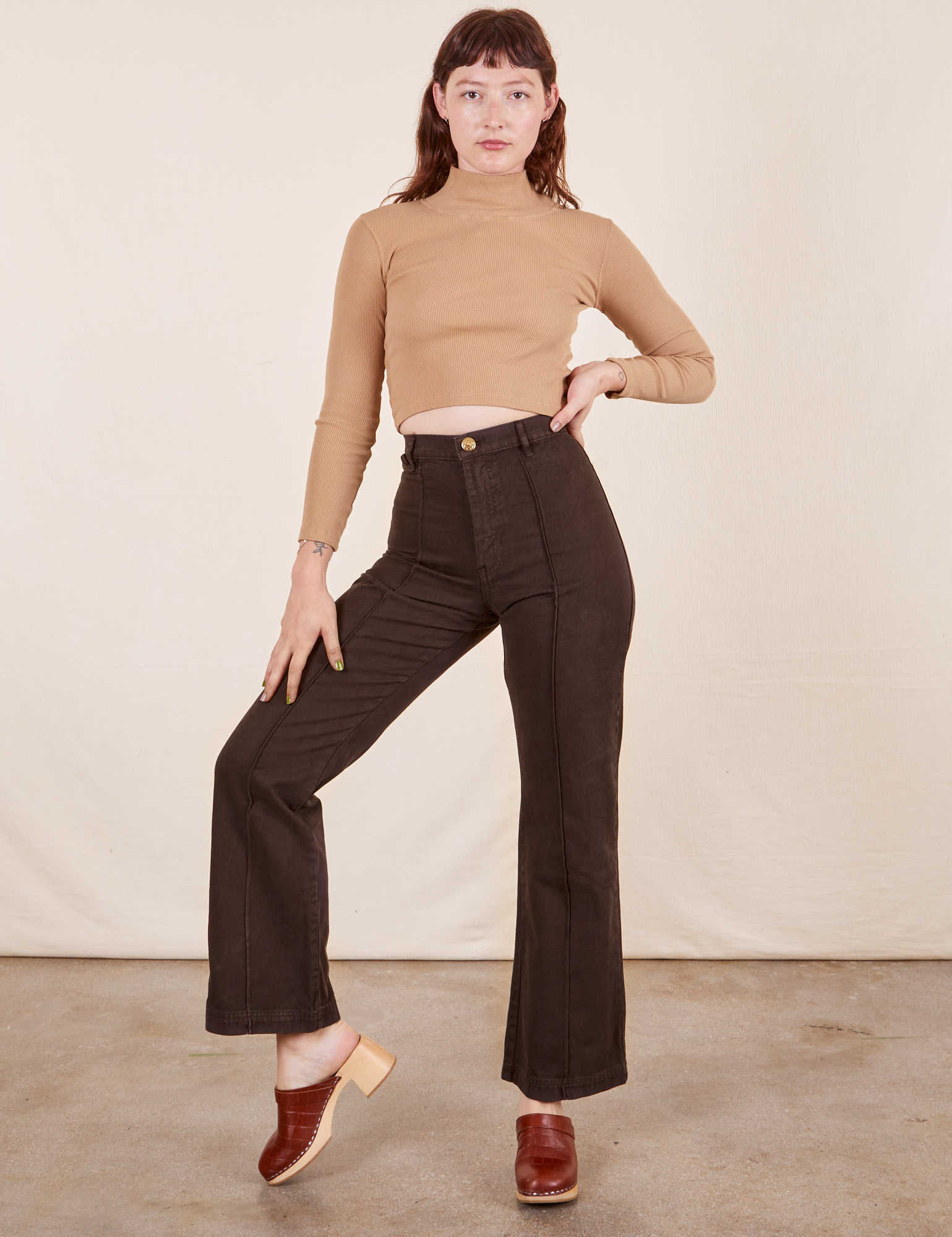 Alex is 5&#39;8&quot; and wearing XS Western Pants in Espresso Brown paired with tan Essential Turtleneck