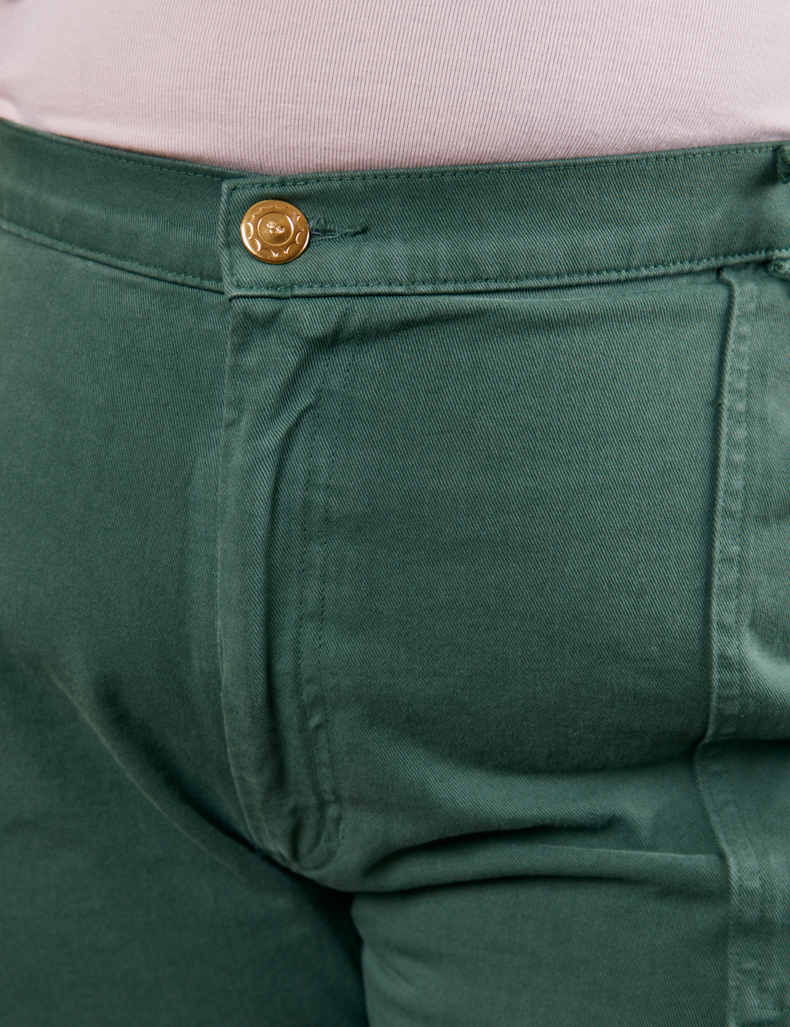 Work Pants in Dark Emerald Green front close up with gold sun baby button on Morgan