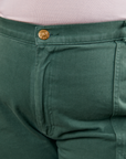 Work Pants in Dark Emerald Green front close up with gold sun baby button on Morgan