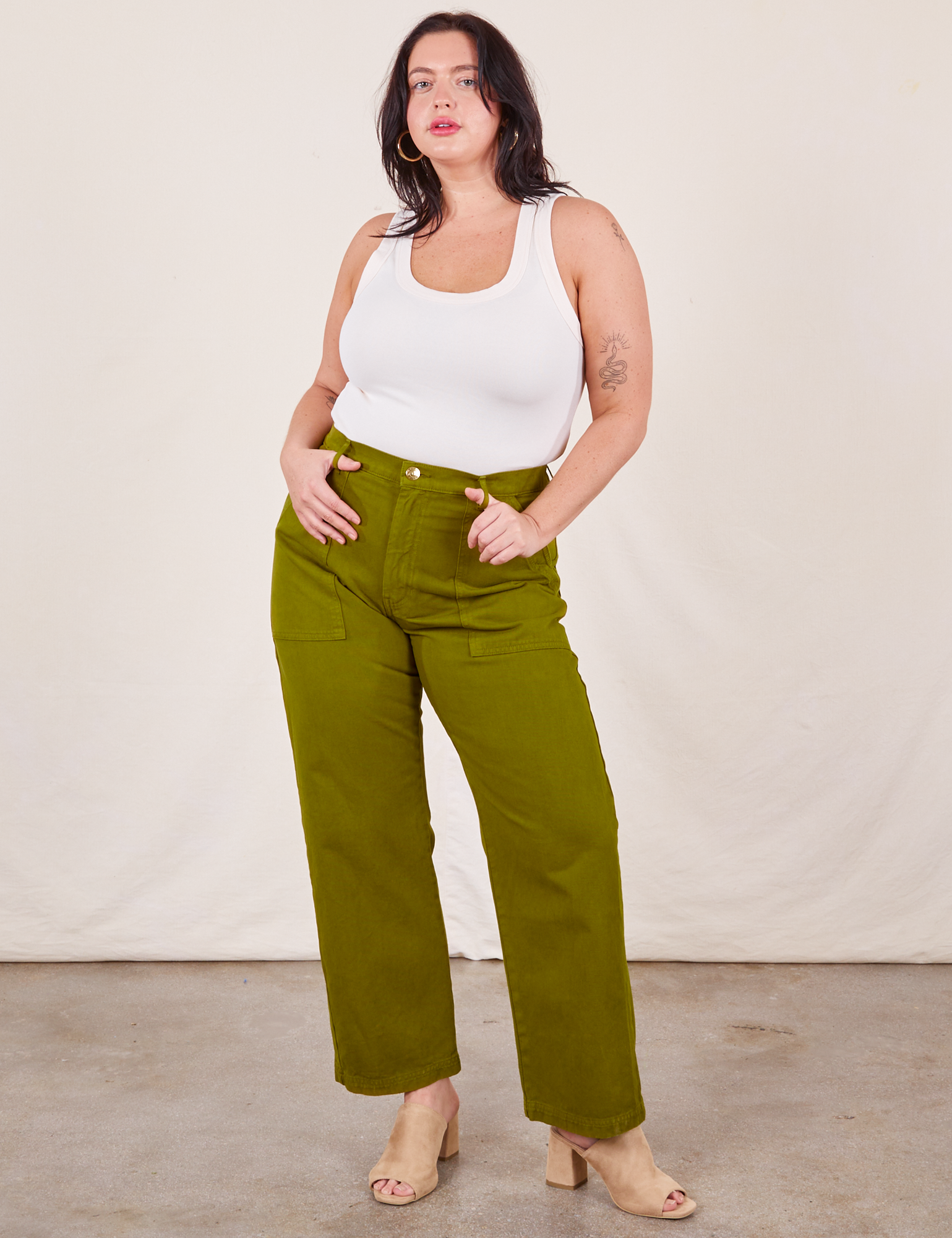 Faye is 5&#39;7&quot; and wearing L Work Pants in Olive Green paired with vintage off-white Tank Top