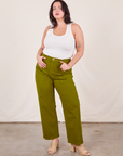 Faye is 5'7" and wearing L Work Pants in Olive Green paired with vintage off-white Tank Top