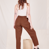 Back view of Checker Trousers in Brown and vintage off-white Tank Top worn by Alex