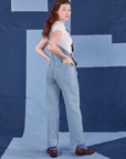 Angled back view of Indigo Denim Original Overalls in Light Wash worn by Alex