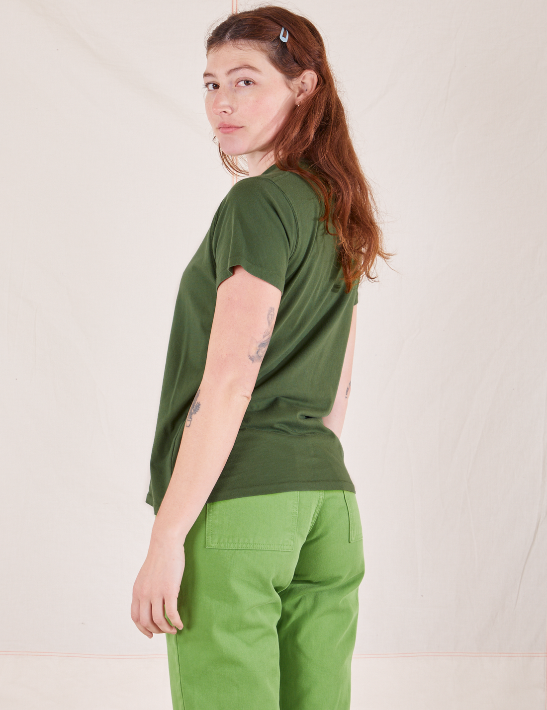 The Organic Vintage Tee in Dark Emerald Green back view on Alex wearing bright olive Western Pants