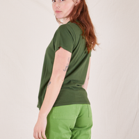 The Organic Vintage Tee in Dark Emerald Green back view on Alex wearing bright olive Western Pants
