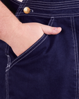 Front pocket close up of Original Overalls in Navy Blue. Mara has her hand in the pocket.