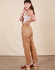 Angled back view of Original Overalls in Tan worn by Alex