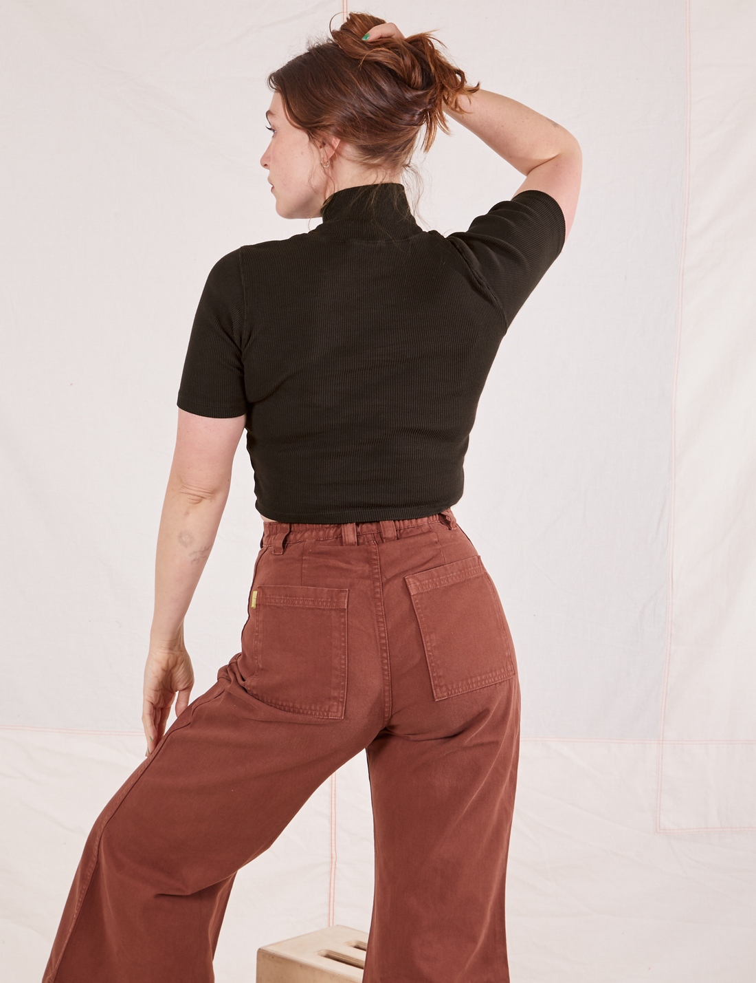 Back view on Allison wearing 1/2 Sleeve Essential Turtleneck in Espresso Brown and fudgesicle brown Bell Bottoms