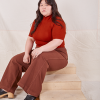 1/2 Sleeve Essential Turtleneck in Paprika on Ashley wearing fudgesicle brown Bell Bottoms sitting on wooden crate
