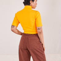 1/2 Sleeve Essential Turtleneck in Sunshine Yellow back view on Mika wearing fudgesicle brown Bell Bottoms