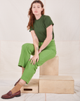 Alex is wearing Organic Vintage Tee in Dark Emerald Green and gross green Western Pants