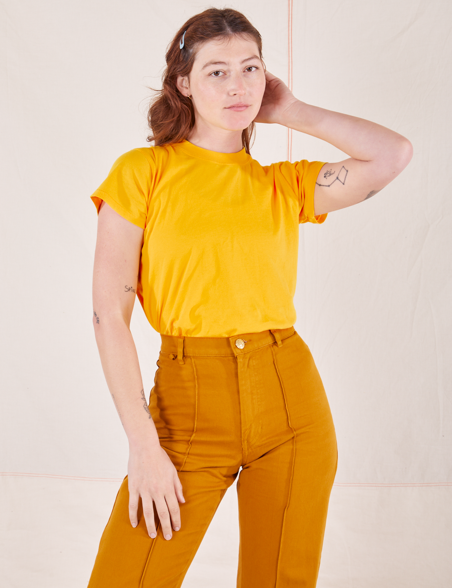 Alex is wearing P Organic Vintage Tee in Sunshine Yellow paired with spicy mustard Western Pants