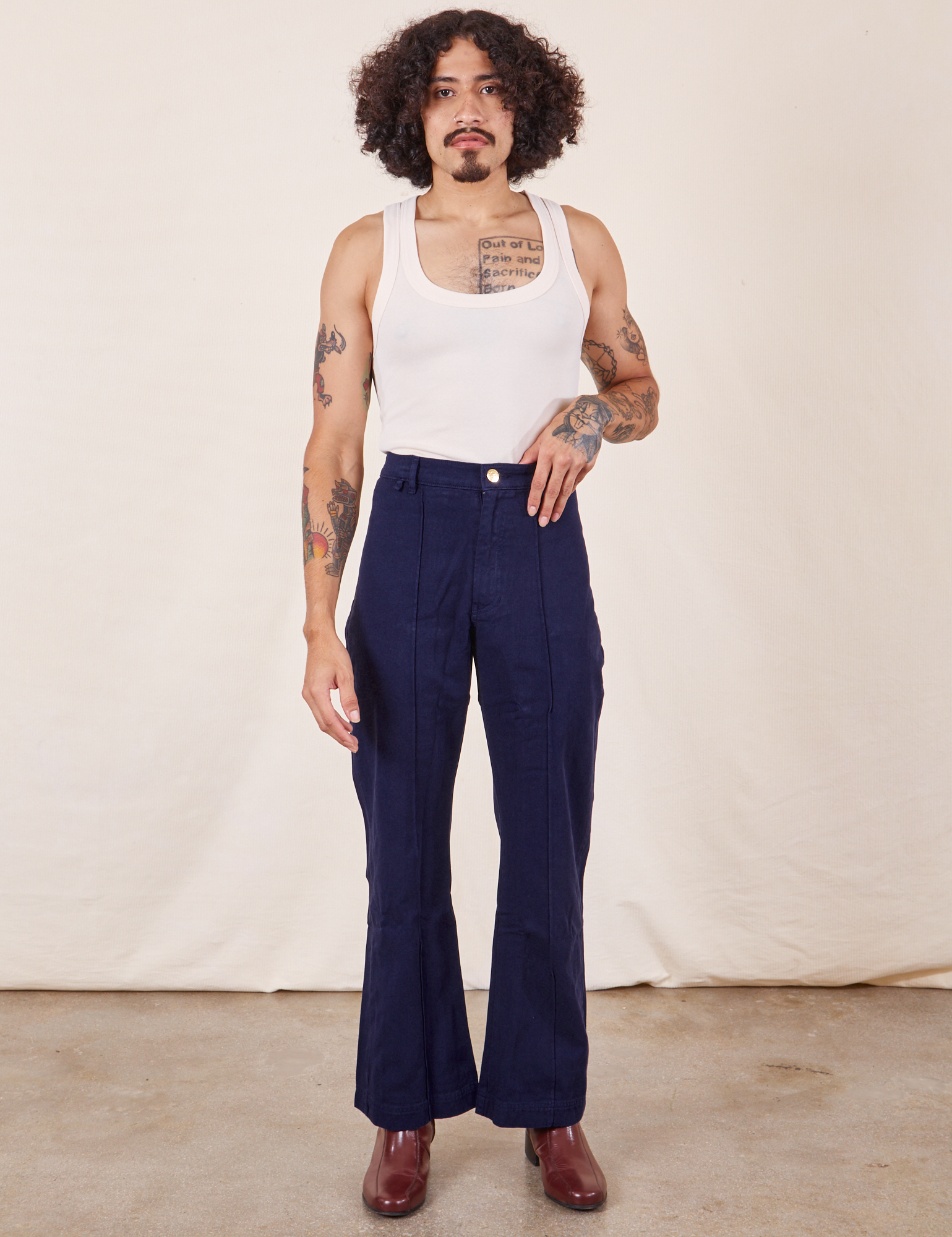 Jesse is 5&#39;8&quot; and wearing XS Western Pants in Navy Blue paired with vintage off-white Tank Top