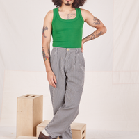 Jesse is 5'8" and wearing XS Checker Trousers in Black & White paired with forest green Tank Top