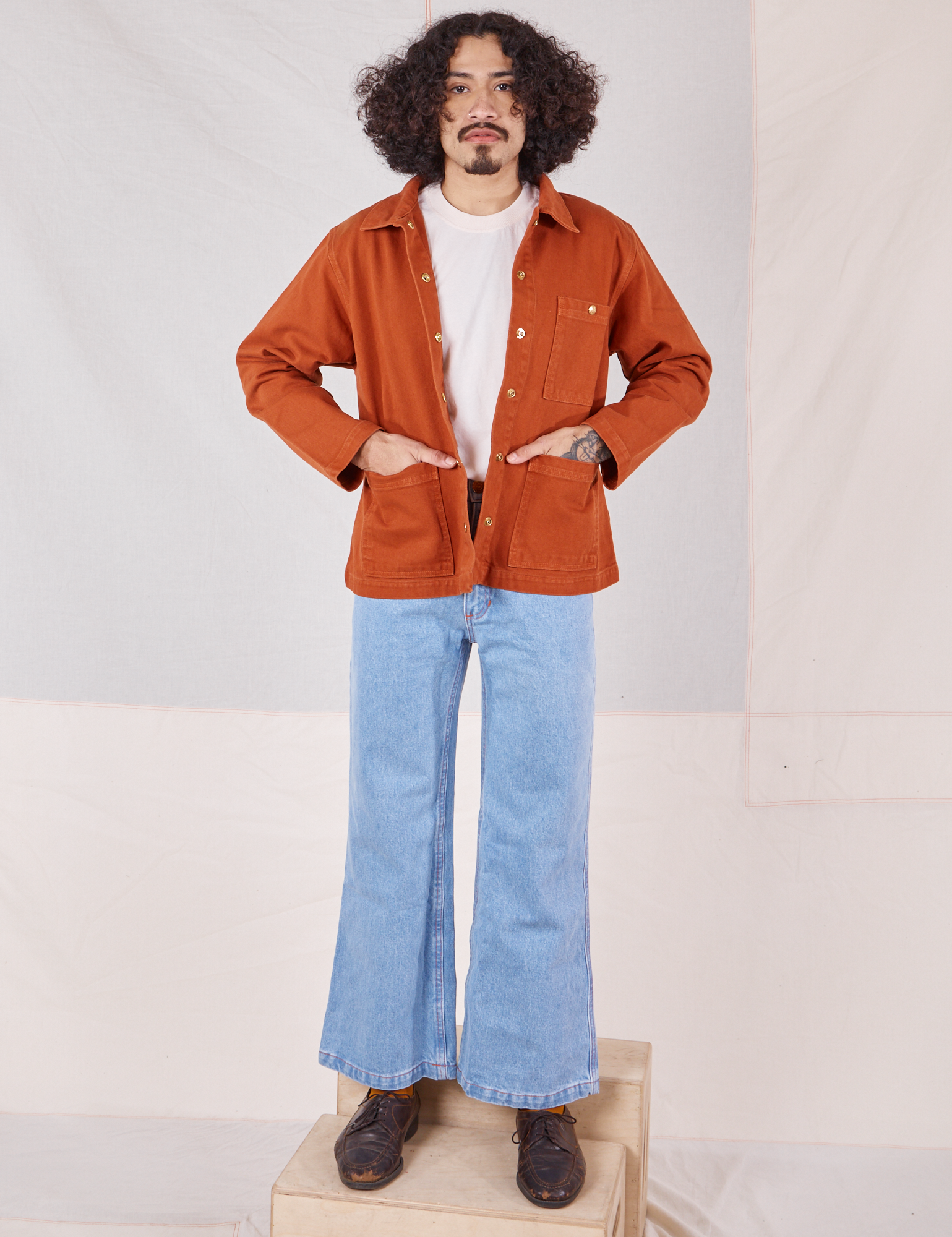 Jesse is wearing Denim Work Jacket in Burnt Terracotta paired with light wash Sailor Jeans