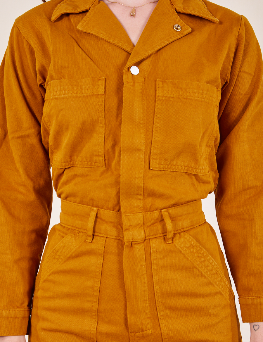Front close up of Everyday Jumpsuit in Spicy Mustard worn by Alex