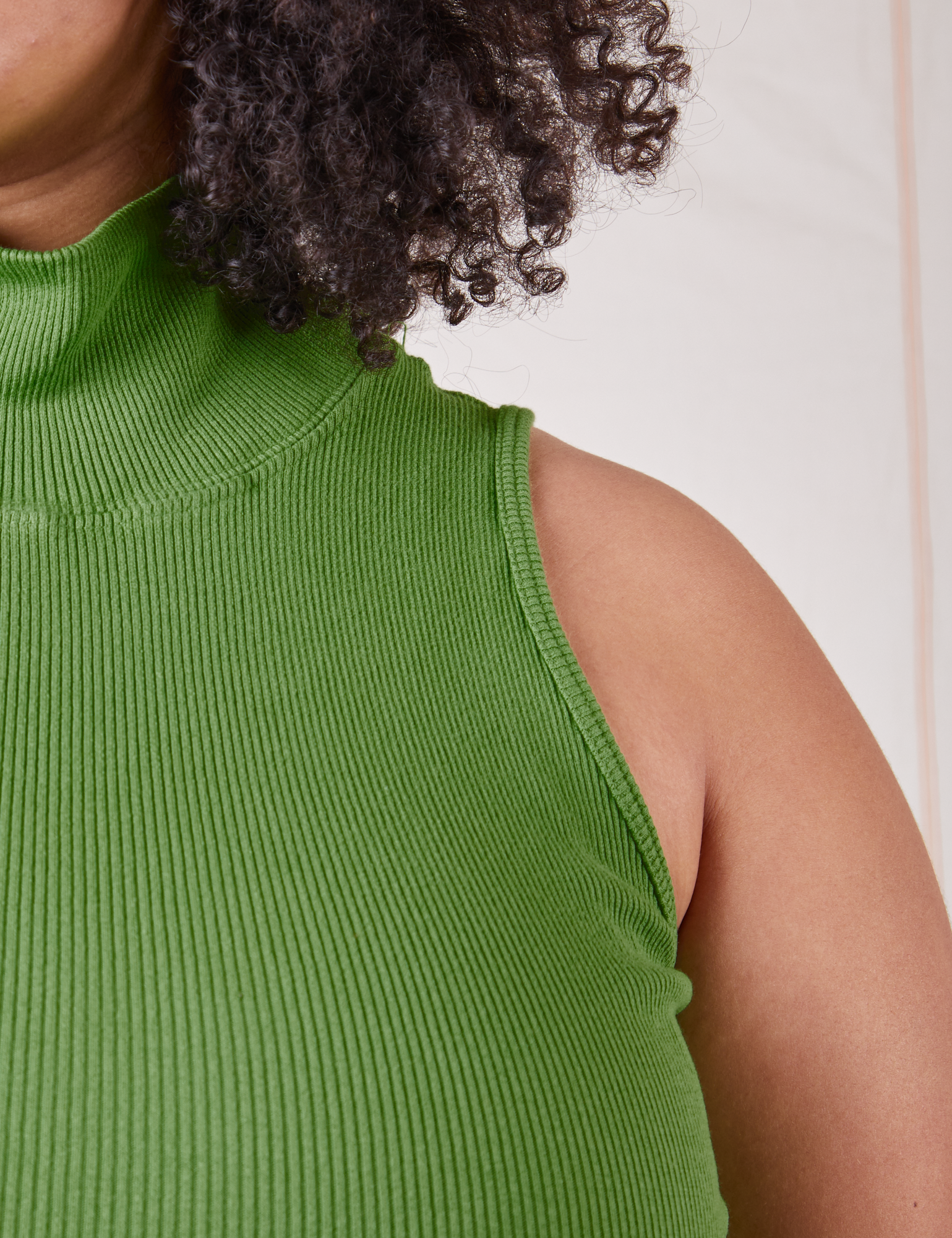 Front close up of Sleeveless Essential Turtleneck in Bright Olive worn by Lana