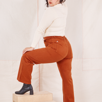 Organic Work Pants in Burnt Terracotta side view on Melanie wearing vintage off-white Long Sleeve Fisherman Polo