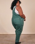 Angled back view of Original Overalls in Dark Emerald Green worn by Morgan