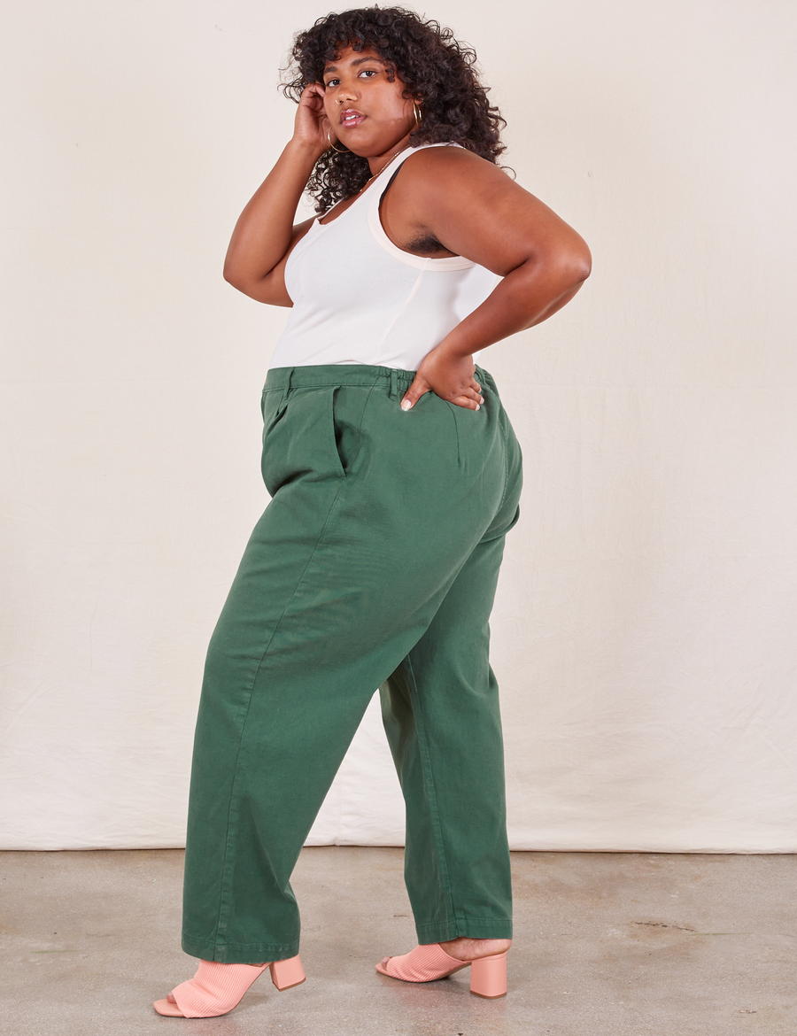 Side view of Heavyweight Trousers in Dark Emerald Green and vintage off-white Tank Top worn by Morgan