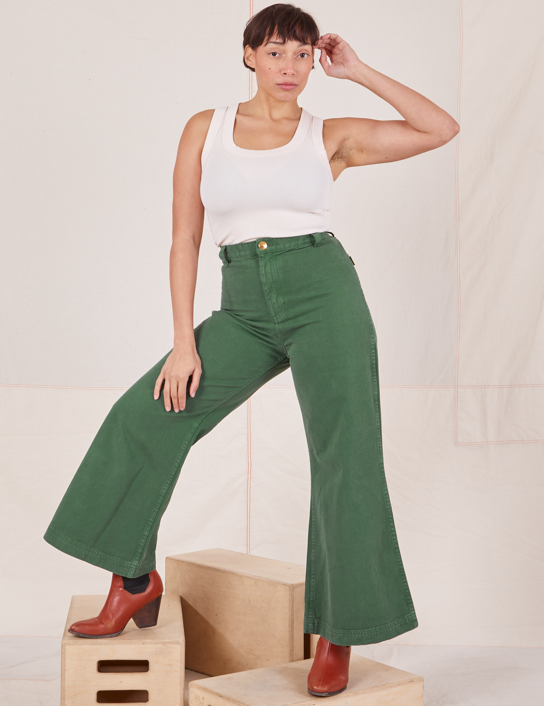 Tiara is 5'4" and wearing XS Bell Bottoms in Dark Emerald Green paired with vintage off-white Tank Top