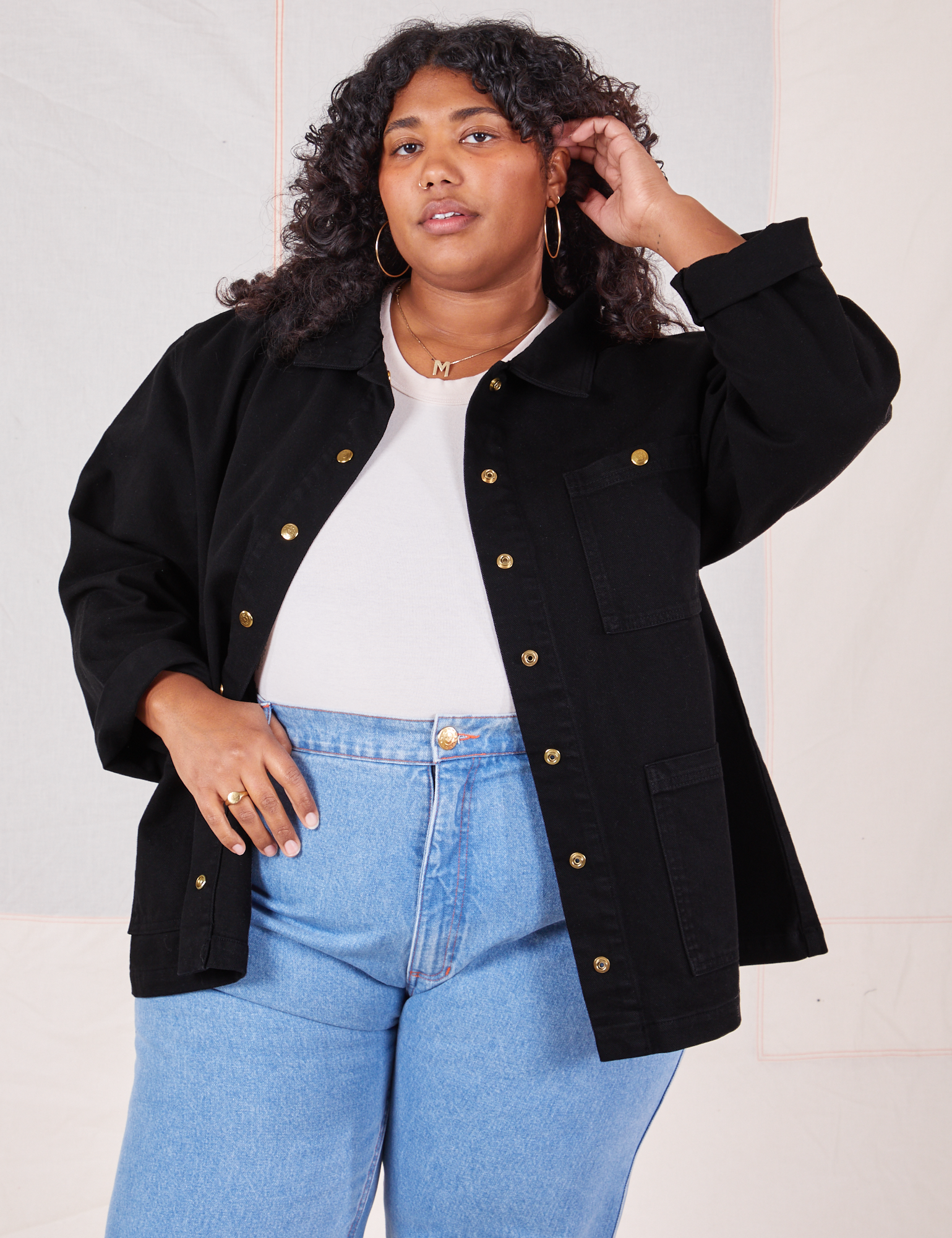 Morgan is wearing Denim Work Jacket in Basic Black with a vintage off-white Baby Tee underneath paired with light wash jeans